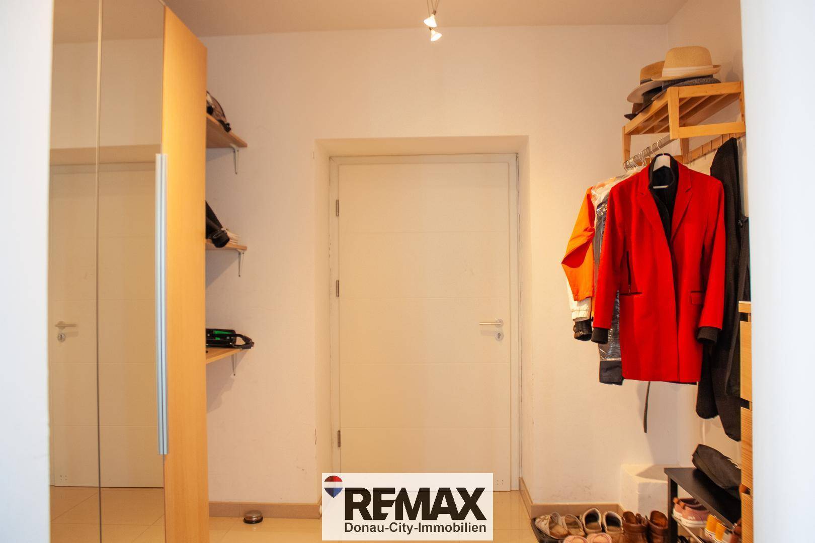 Praktischer Flurbereich mit Spiegelschrank und offener Garderobe für Kleidung und Accessoires.