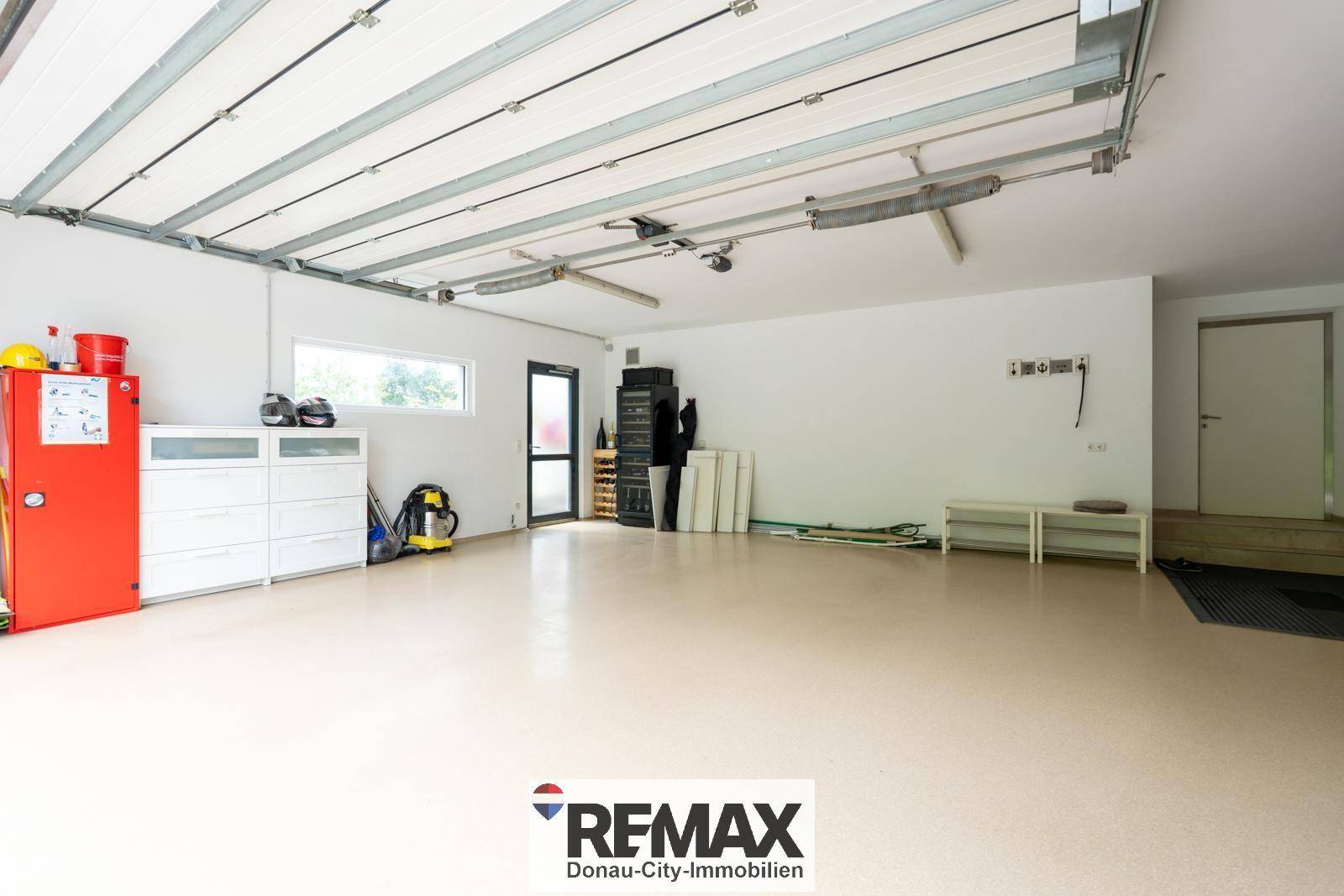 Innenansicht einer sauberen und geräumigen Garage mit Stauraum und Fenster.