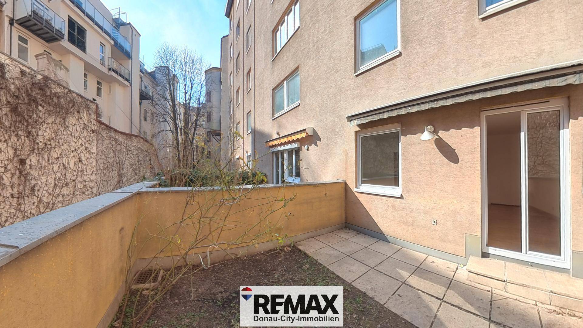 Kleine Terrasse im Erdgeschoss mit gepflastertem Bereich und direktem Zugang zum Garten.