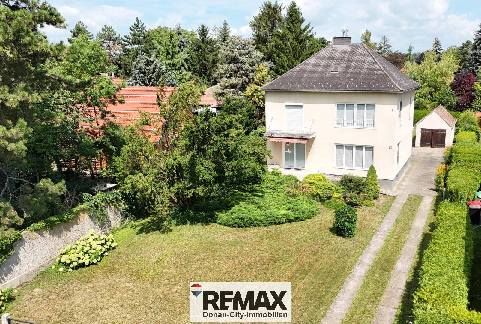 Luftaufnahme des Einfamilienhauses mit großem Garten und Zufahrt.