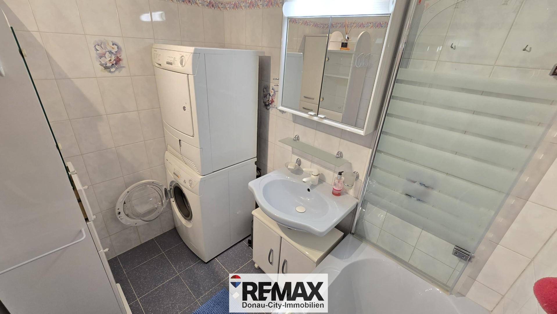 Badezimmer mit Waschmaschine, Trockner und Waschbecken, praktisch für den Haushalt.