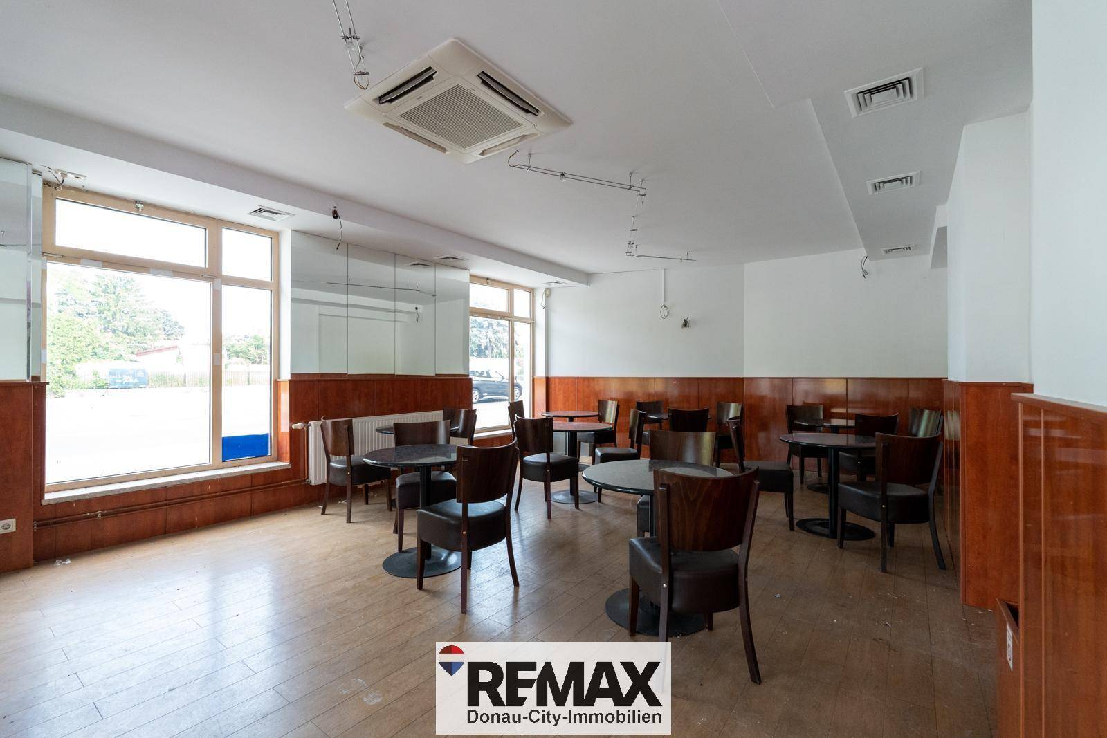 Großer Gewerberaum mit vielen Tischen und Stühlen, ideal für ein Café oder Restaurant.