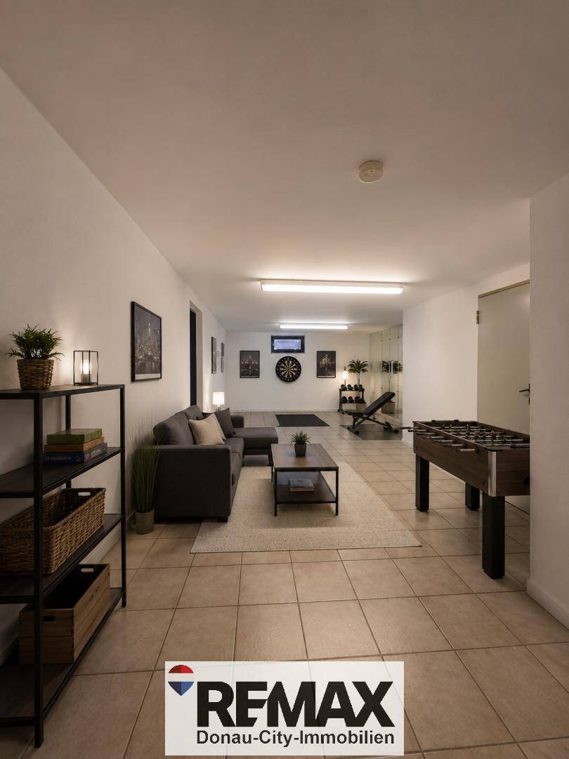 Ausgebauter Kellerraum mit Sofa, Tischfußball und Fitnessbereich.
