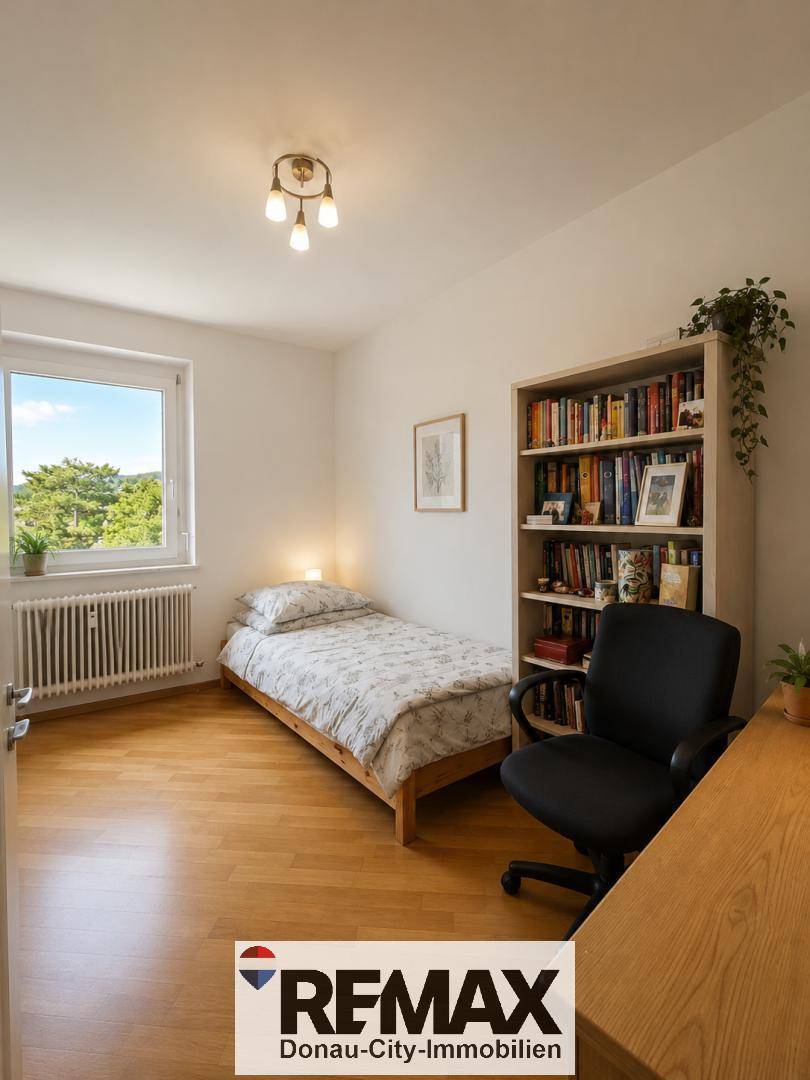 Helles Schlafzimmer oder Arbeitszimmer mit Einzelbett, Schreibtisch und Bücherregal.