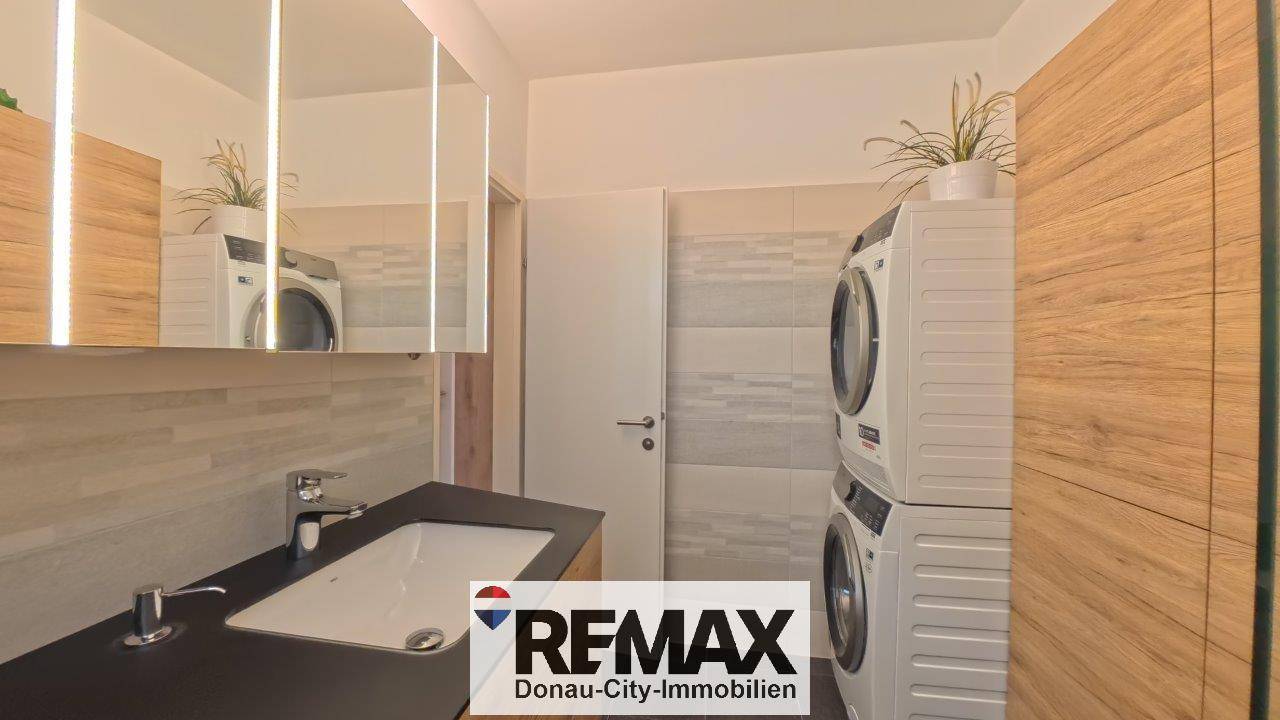 Modernes Badezimmer mit Waschbecken, Waschmaschine und Trockner.