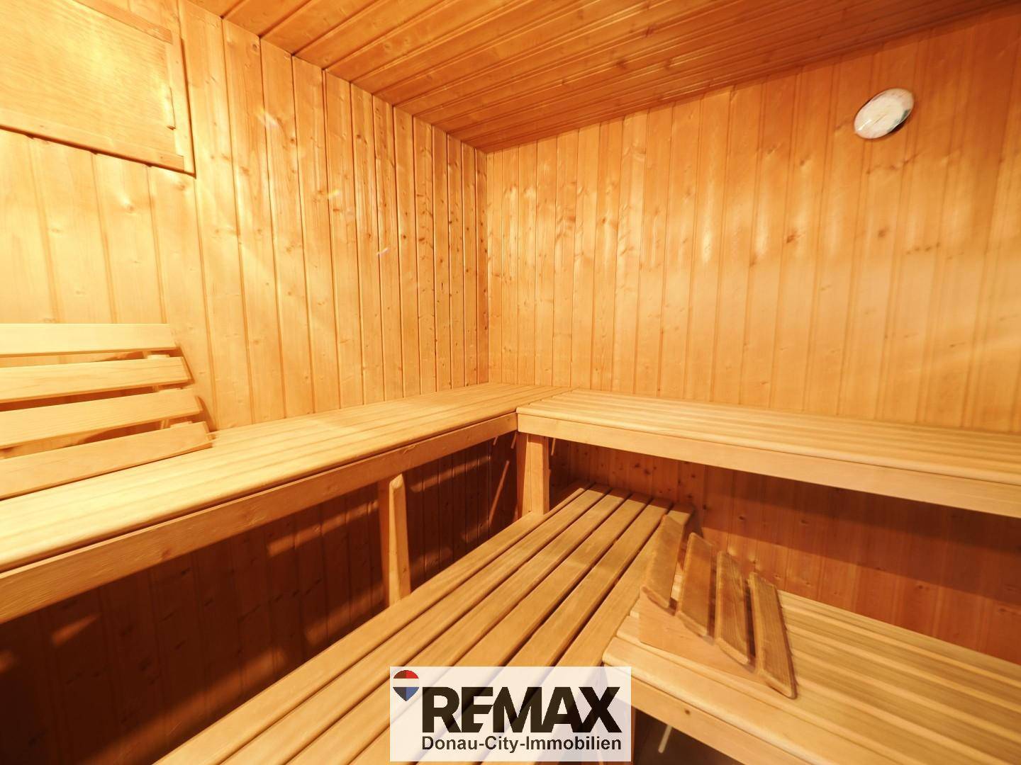 Traditionelle Sauna mit Holzwänden und mehreren Sitzbänken, die zum Entspannen einlädt.