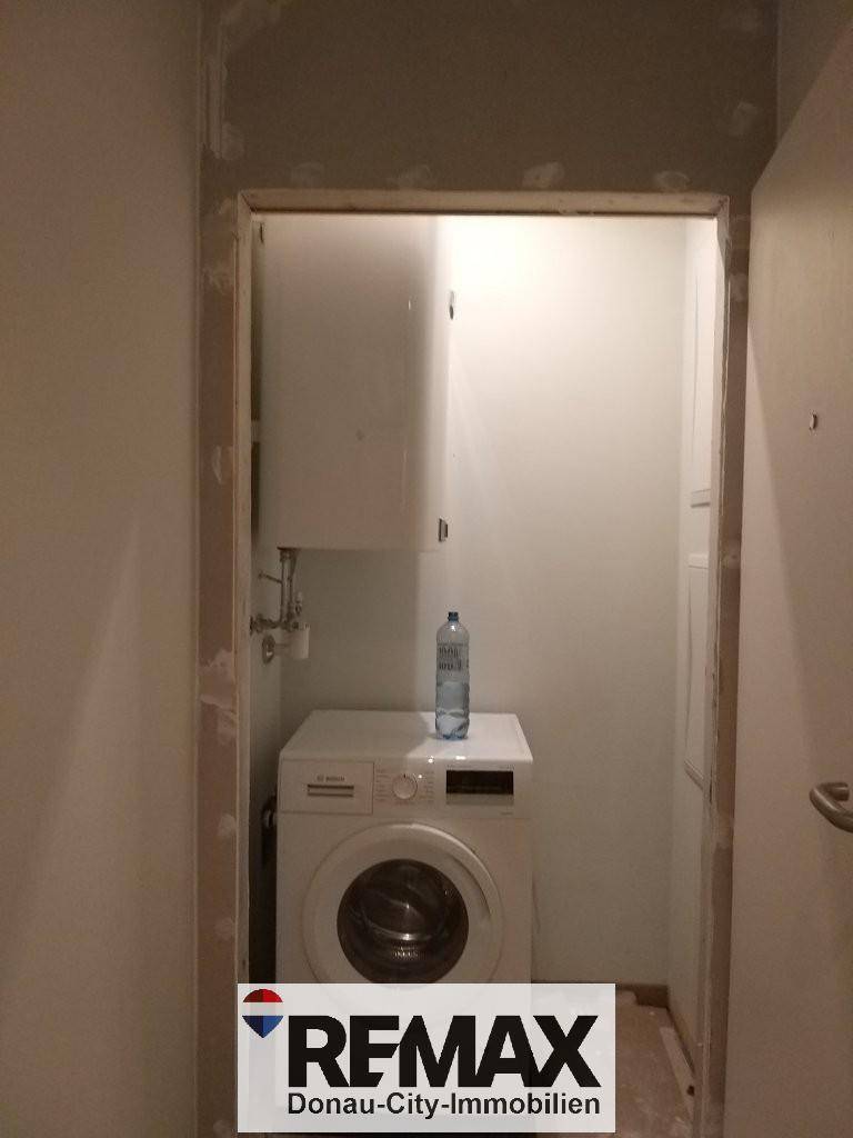 Praktischer Hauswirtschaftsraum mit Waschmaschine und Warmwasserboiler.