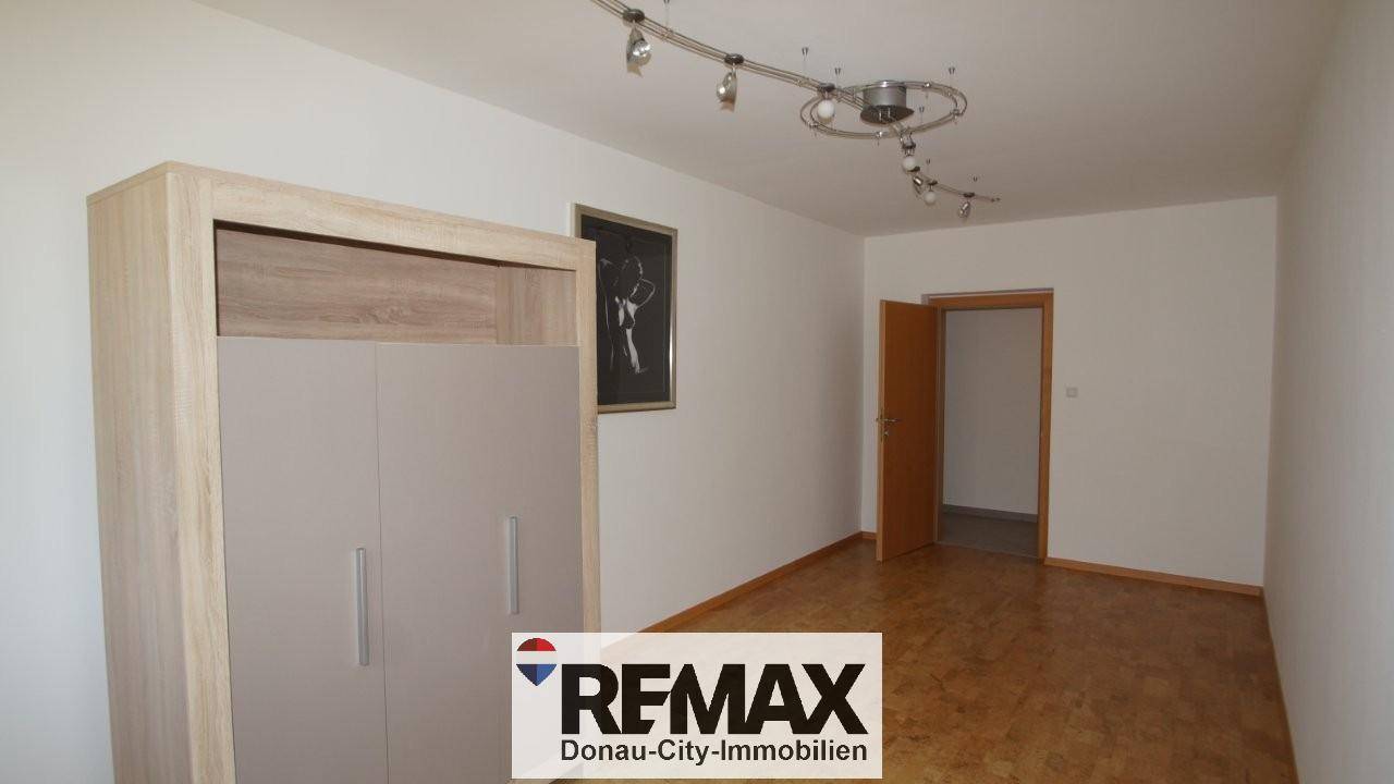 Geräumiger Raum mit Parkettboden und einem Kleiderschrank, bietet flexible Nutzungsmöglichkeiten.