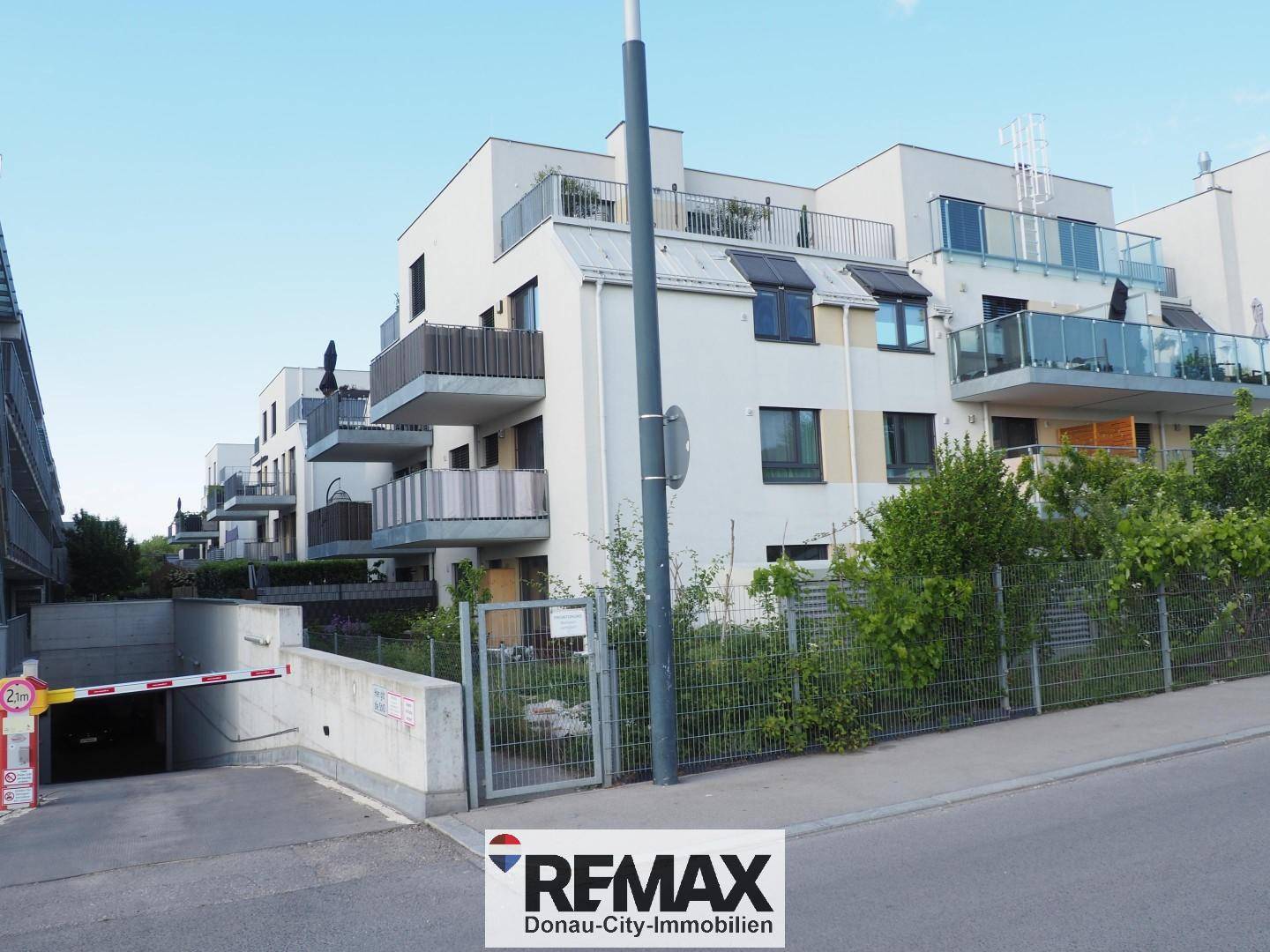 Moderne Wohnanlage mit Tiefgaragenzufahrt und gepflegter Außenanlage.