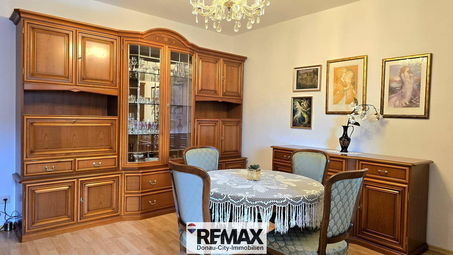 Essbereich mit rundem Tisch, eleganten Stühlen und einer großen traditionellen Schrankwand.