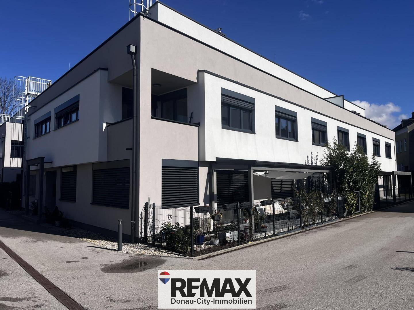 Moderne Gebäudefassade mit überdachter Terrasse und Außenbereich für entspannte Stunden.