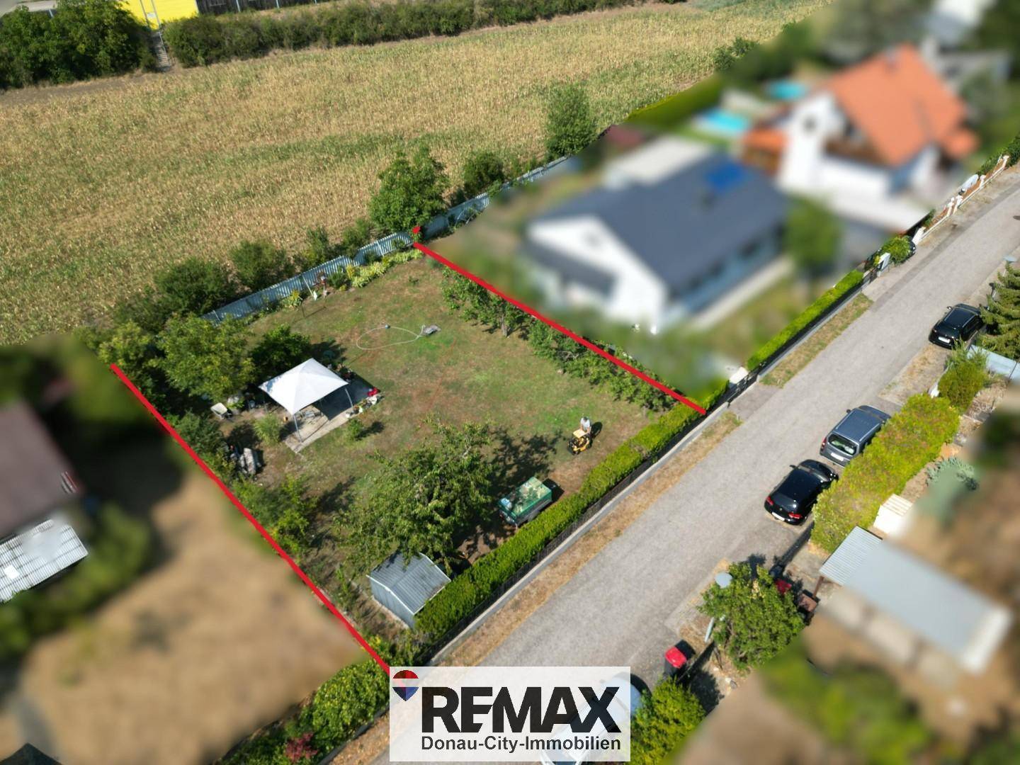 Luftaufnahme eines Grundstücks mit Garten, umgeben von Feldern und einer Straße.