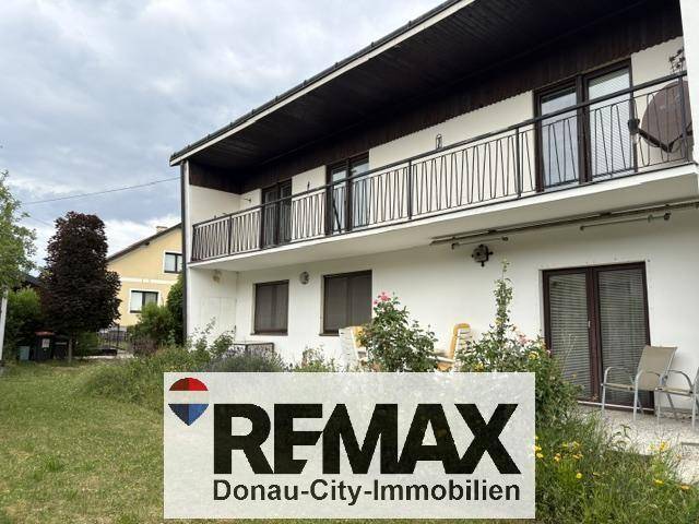 Hausfassade mit Terrasse und Gartenbereich, ideal für entspannte Stunden im Freien.