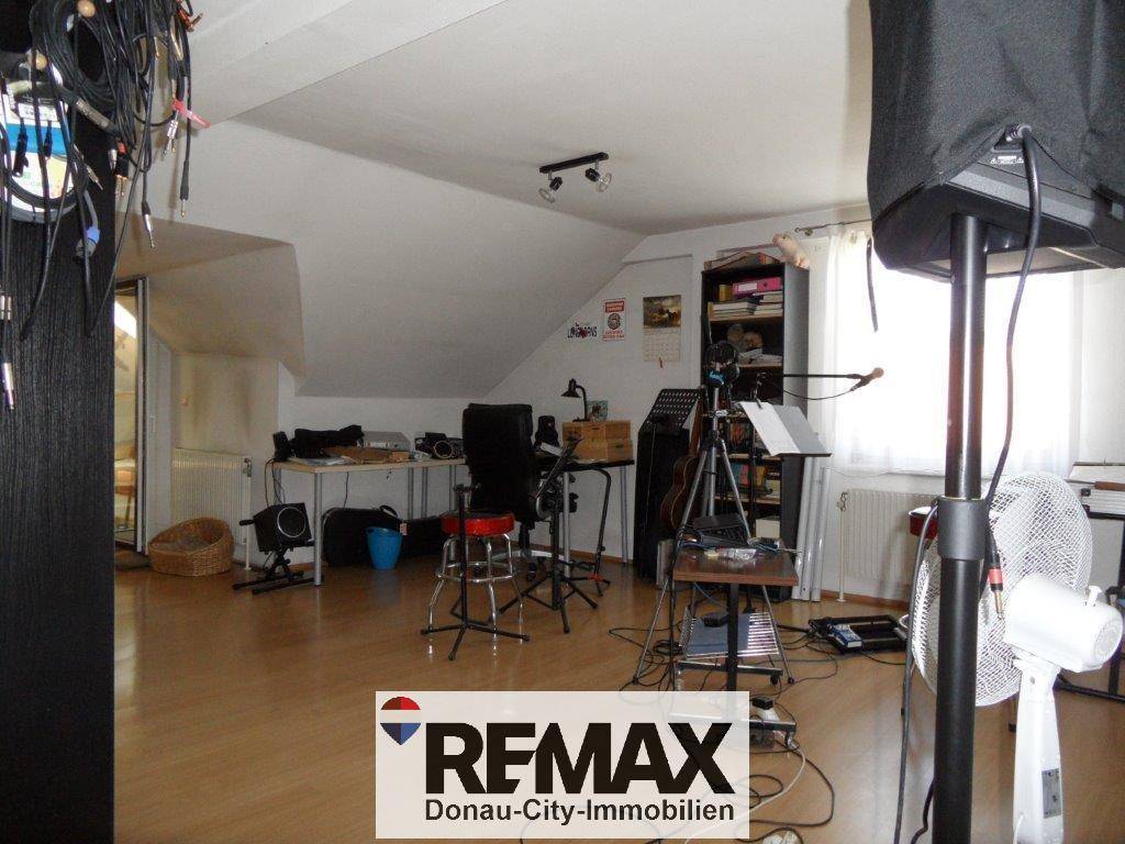 Dachgeschossraum mit schrägen Wänden, genutzt als Musik- oder Hobbyzimmer mit diverser Ausrüstung.