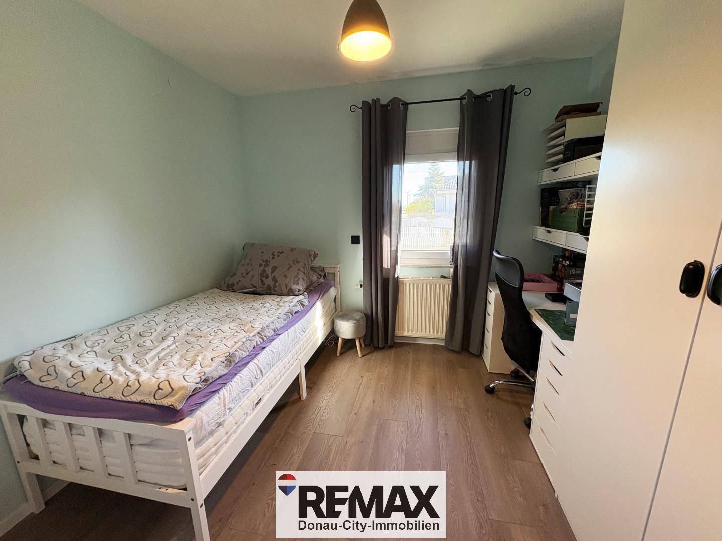 Kinderzimmer mit Einzelbett, Schreibtisch und Schrank, hell und funktional eingerichtet.