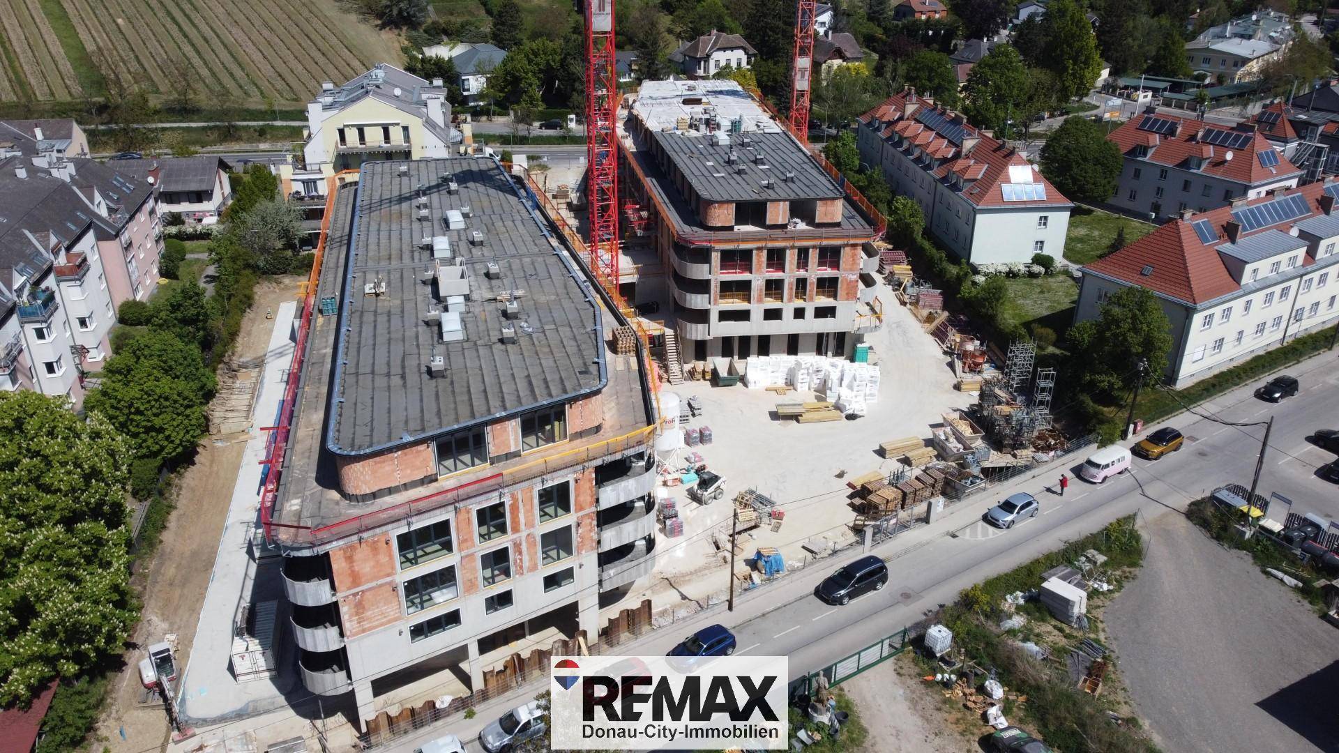 Überblick über die Baustelle mit zwei modernen Gebäuden in fortgeschrittenem Bauzustand.