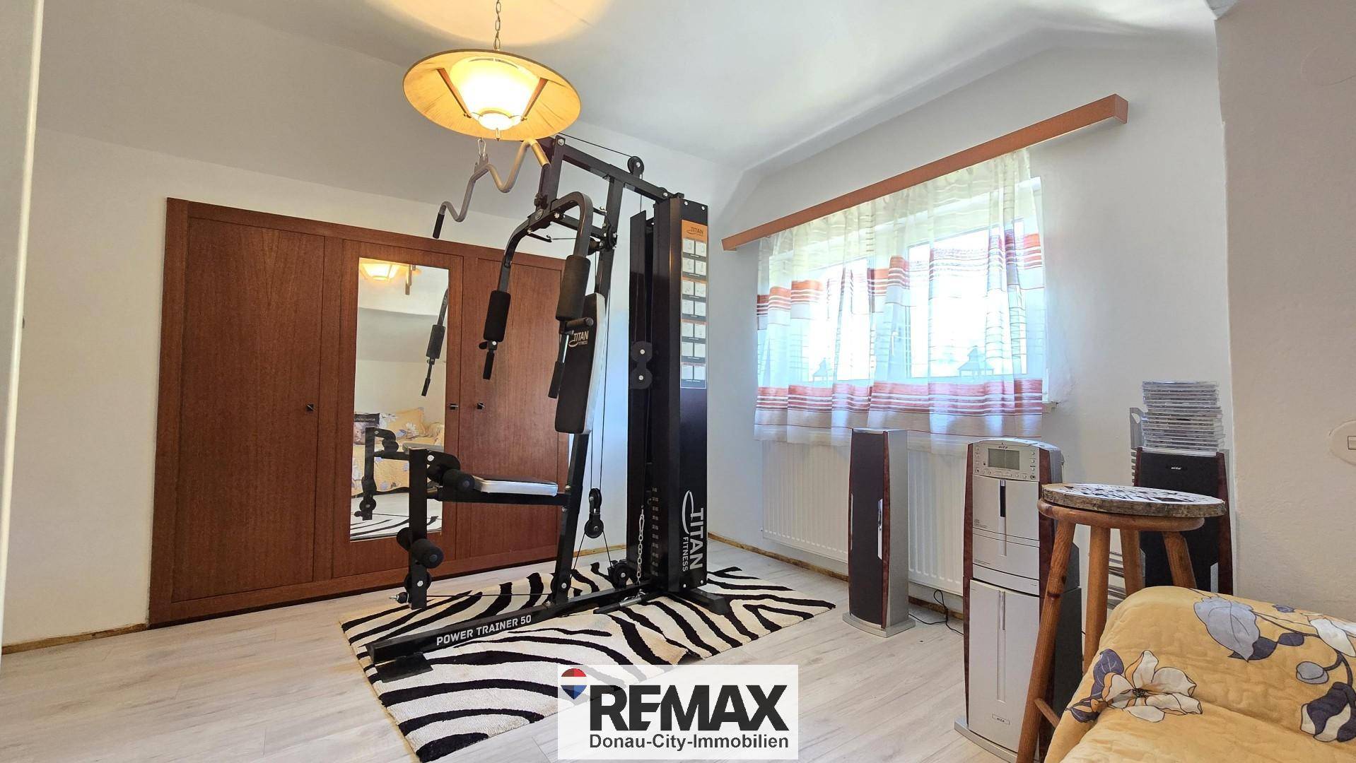 Raum mit Fitnessgerät, Kleiderschrank und Fenster.
