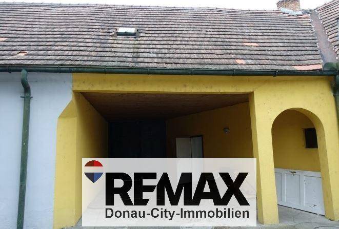 Offener Garagenbereich oder Carport mit gelb gestrichenen Wänden und einem Dachfenster.