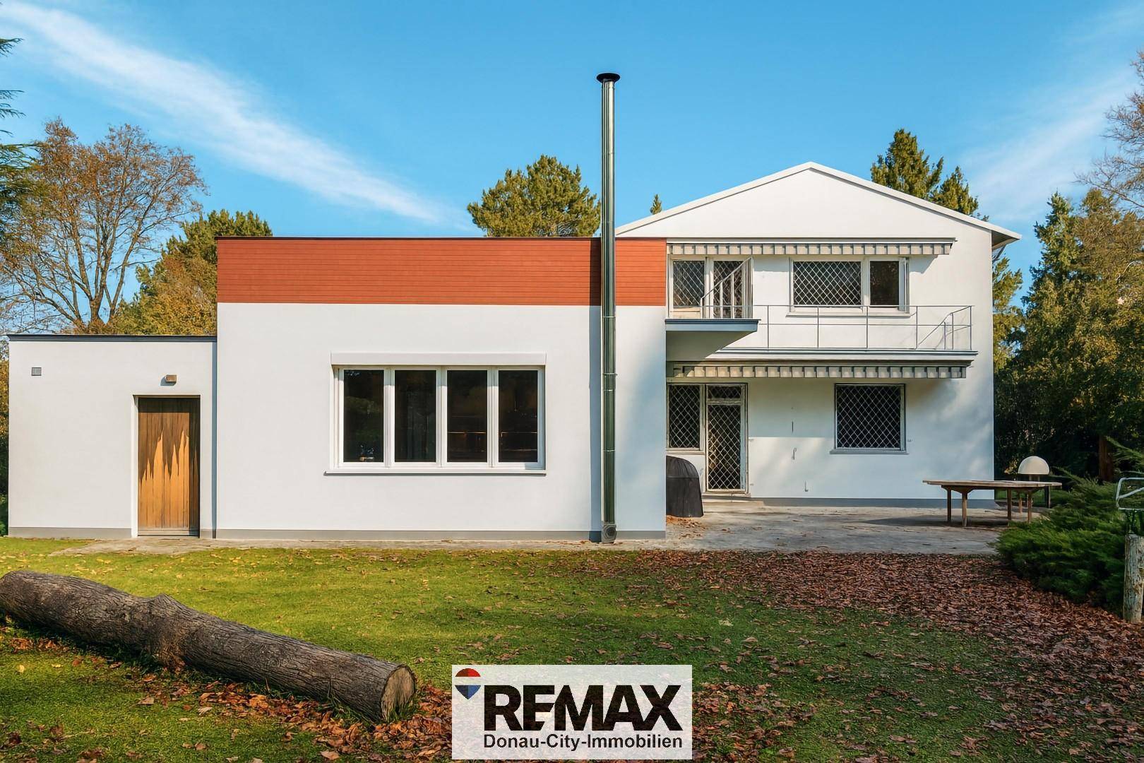 Rückansicht des Hauses mit großem Garten, Rasenfläche und altem Baumbestand.