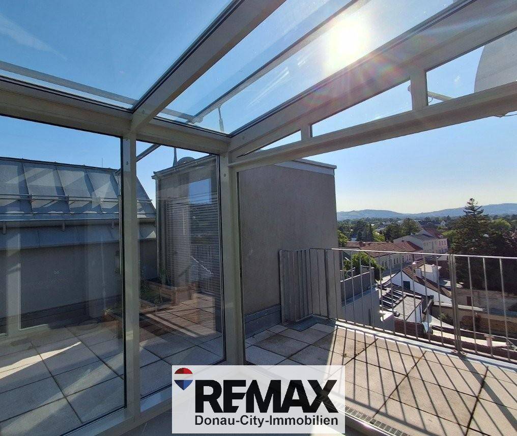 Sonnige Dachterrasse mit Glasanbau und weitem Blick über die Umgebung.