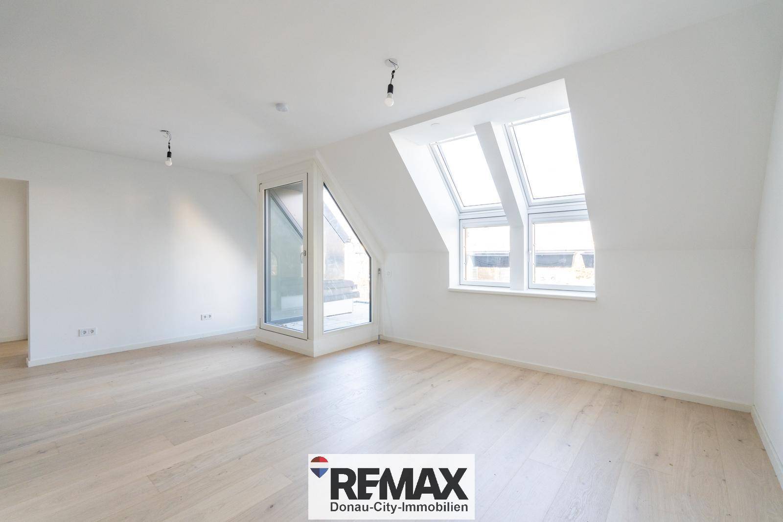Lichtdurchfluteter Wohnbereich mit Dachschrägen und großen Dachfenstern, ideal für Entspannung.