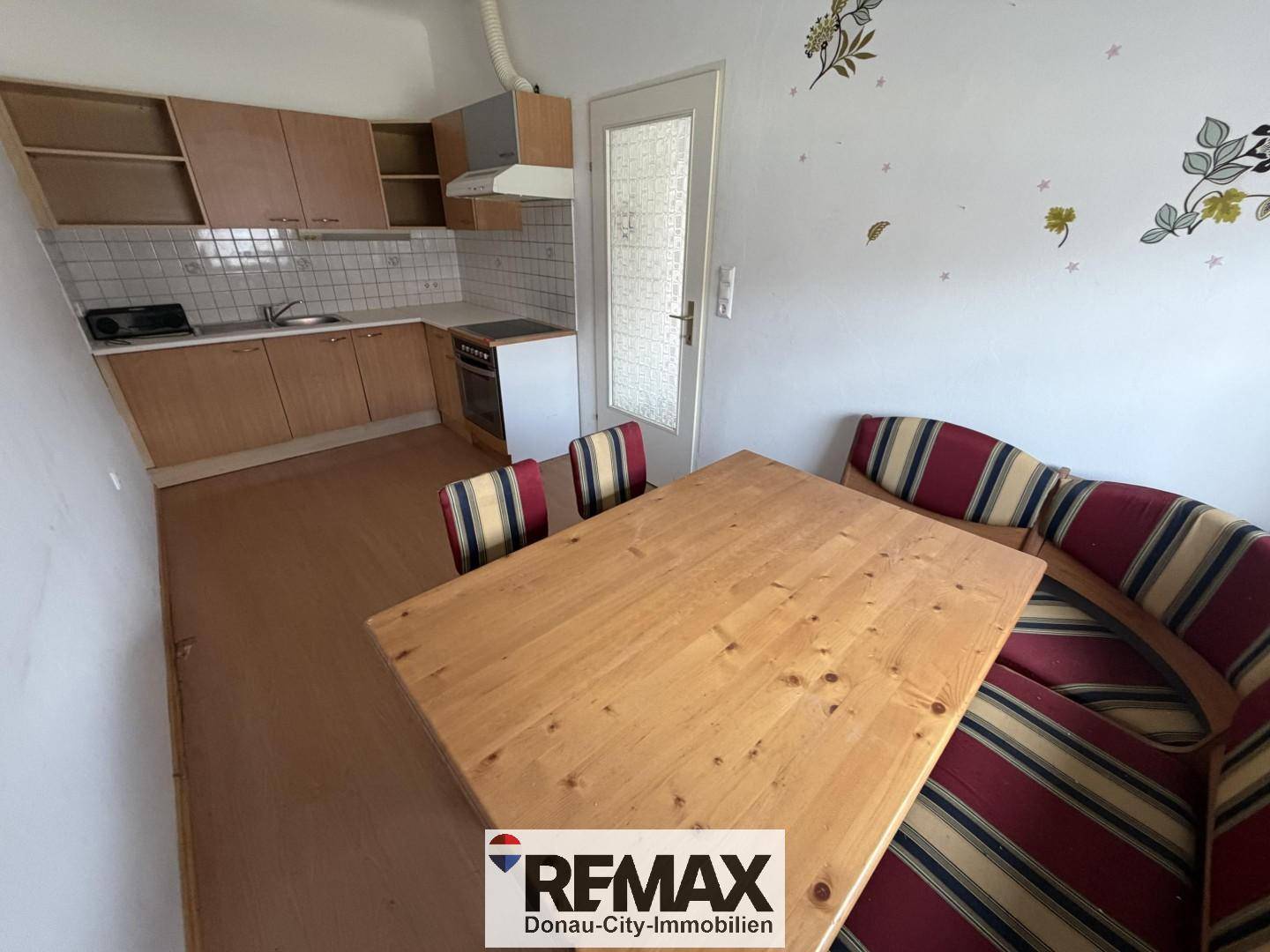 Geräumige Küche mit Essbereich, Holzmöbeln und Laminatboden, ideal für Familien.
