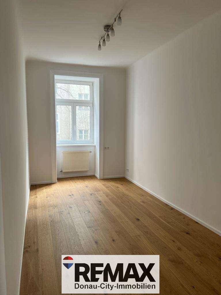 Freundlicher Raum mit Holzboden und Fenster, der vielseitig genutzt werden kann.