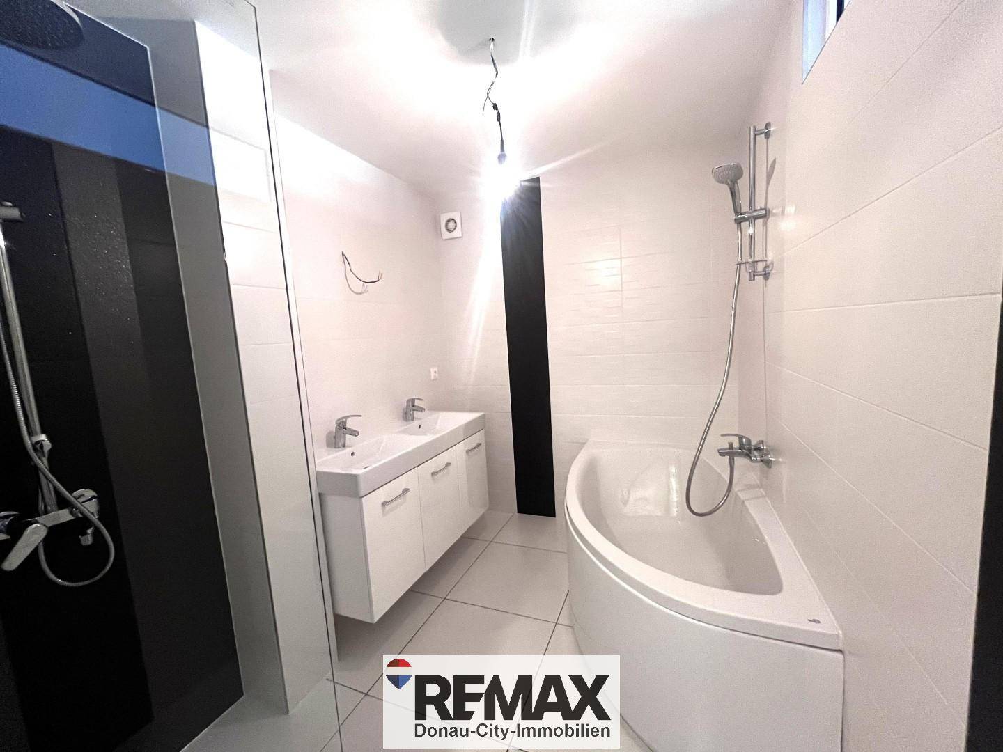 Modernes Badezimmer mit Doppelwaschbecken, Eckbadewanne und separater Dusche.