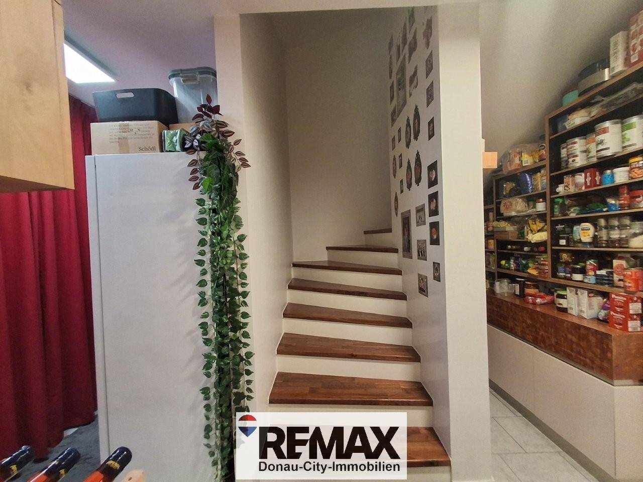 Praktische Speisekammer mit Regalen voller Vorräte und Zugang über eine Treppe.