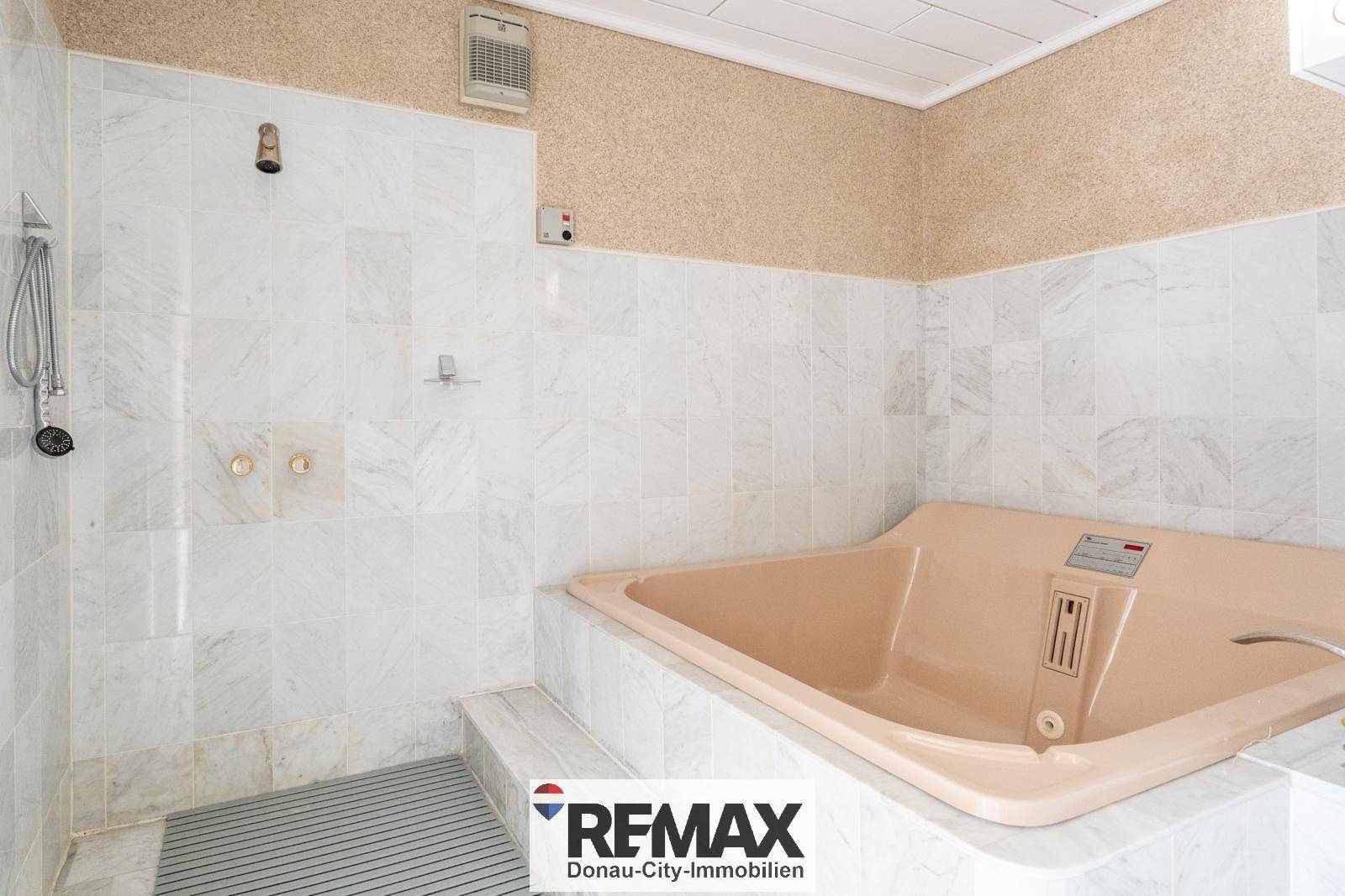 Geräumiges Badezimmer mit großer Badewanne, Duschbereich und hellen Fliesen.