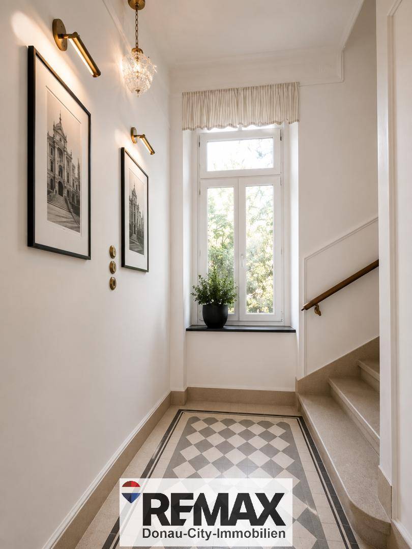 Heller Eingangsbereich mit gemustertem Fliesenboden, Fenster und Treppenaufgang.