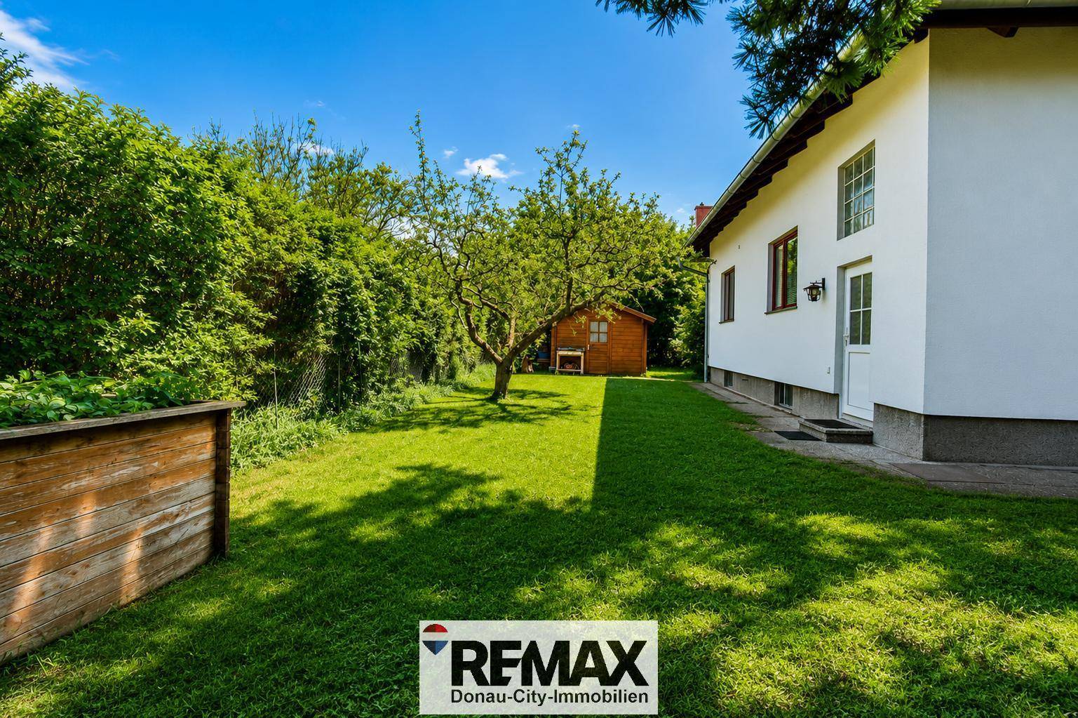 Großer, gepflegter Garten mit Rasenfläche, Bäumen und einem charmanten Gartenhaus.