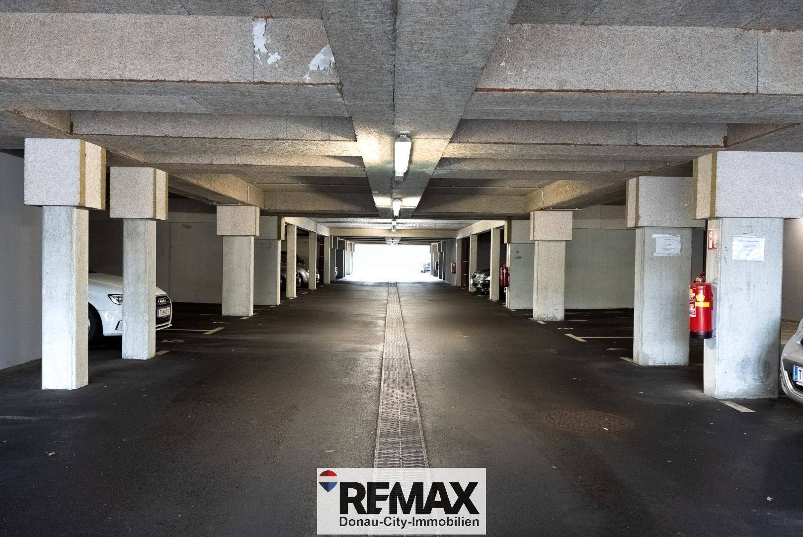 Geräumige Tiefgarage mit Betonpfeilern und Beleuchtung, bietet ausreichend Parkplätze.