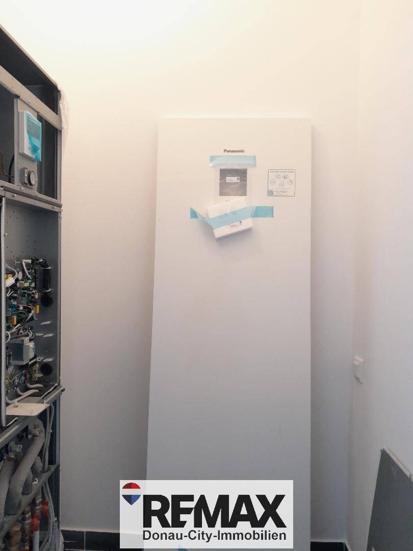 Technikraum mit einer modernen Panasonic Wärmepumpe und weiteren Installationen.