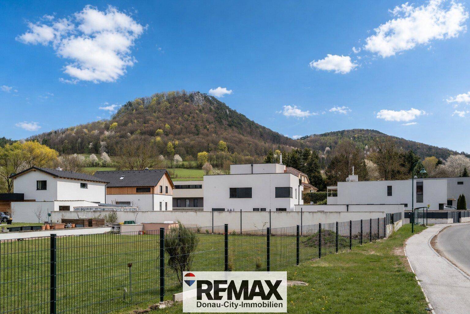 Moderne Wohngebäude in einer grünen Umgebung mit beeindruckendem Bergblick.