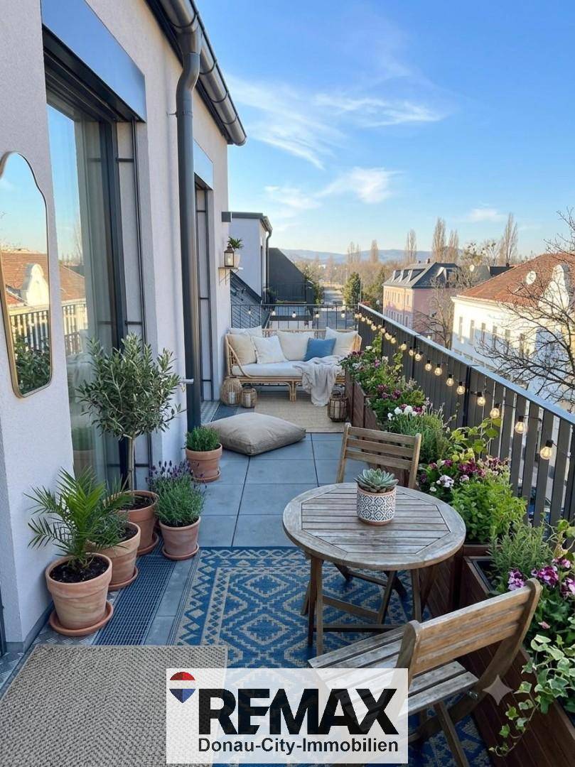 Gemütlicher Balkon mit Sitzgelegenheiten, Pflanzen und Blick auf die Umgebung.