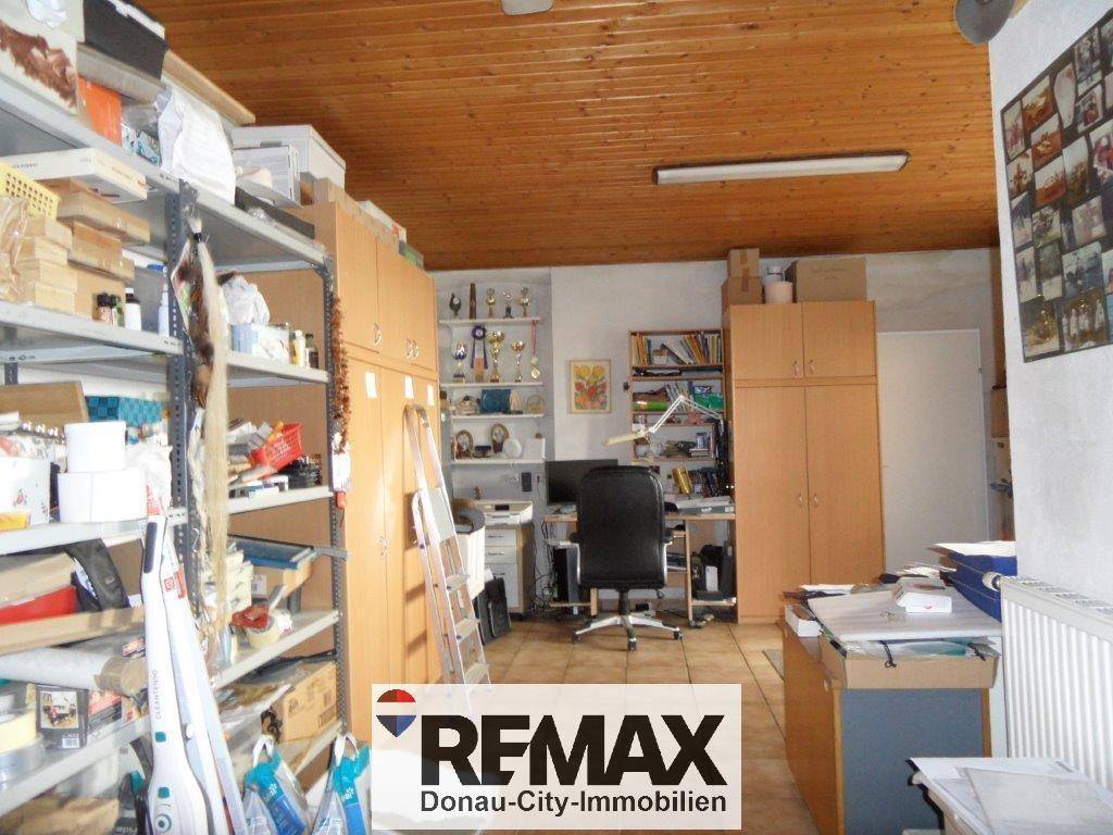 Geräumiges Büro oder Arbeitszimmer mit Holzdecke, Regalen und einem Schreibtisch, ideal für die Arbeit.
