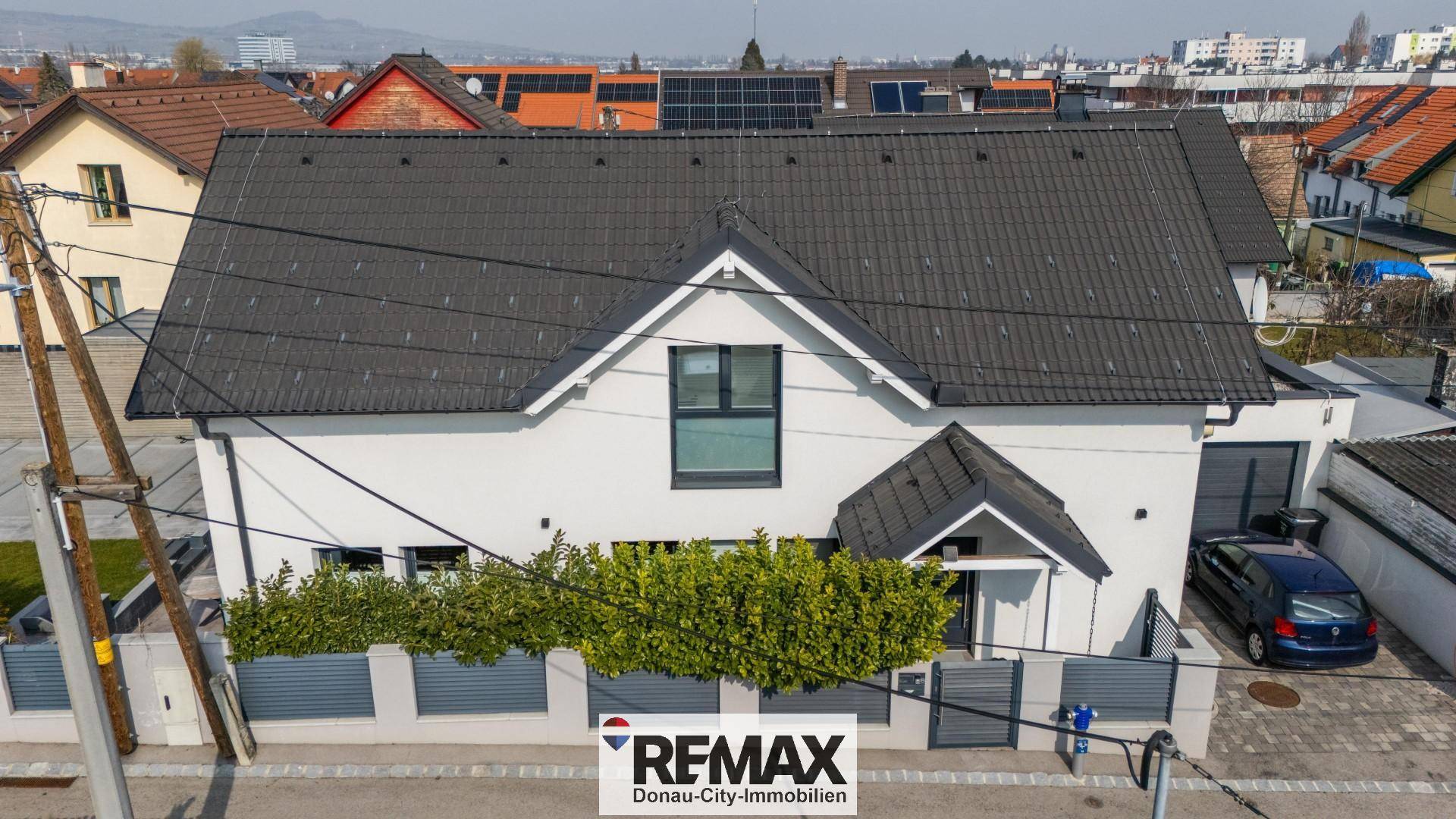 Modernes Einfamilienhaus mit Satteldach und gepflegter Fassade in einer Wohnsiedlung.