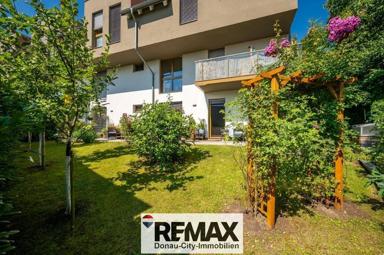 Moderner Gebäudekomplex mit gepflegtem Garten und kleinen Terrassenbereichen.