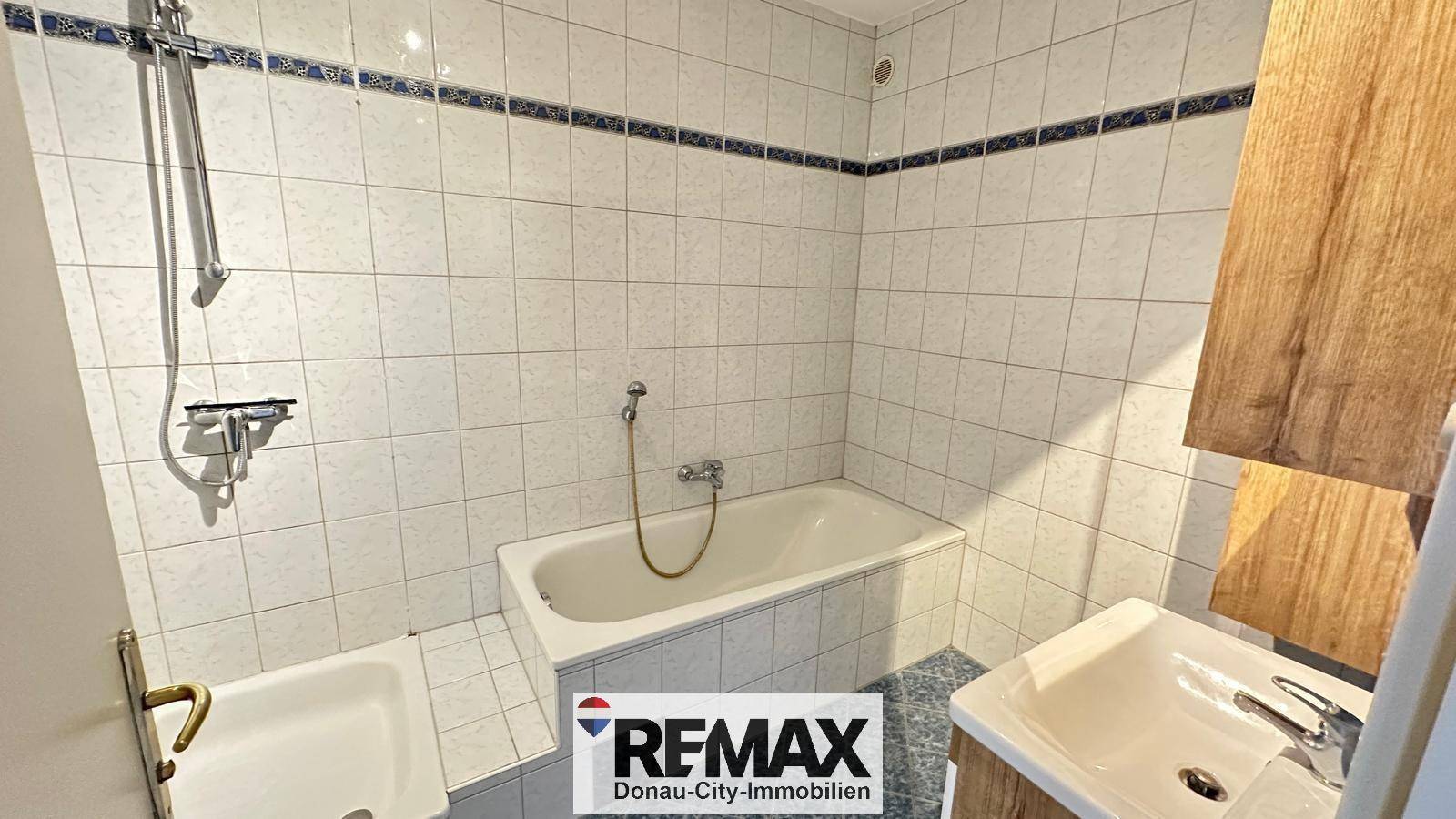 Gefliestes Badezimmer mit Badewanne, Waschbecken und WC in klassischem Design.