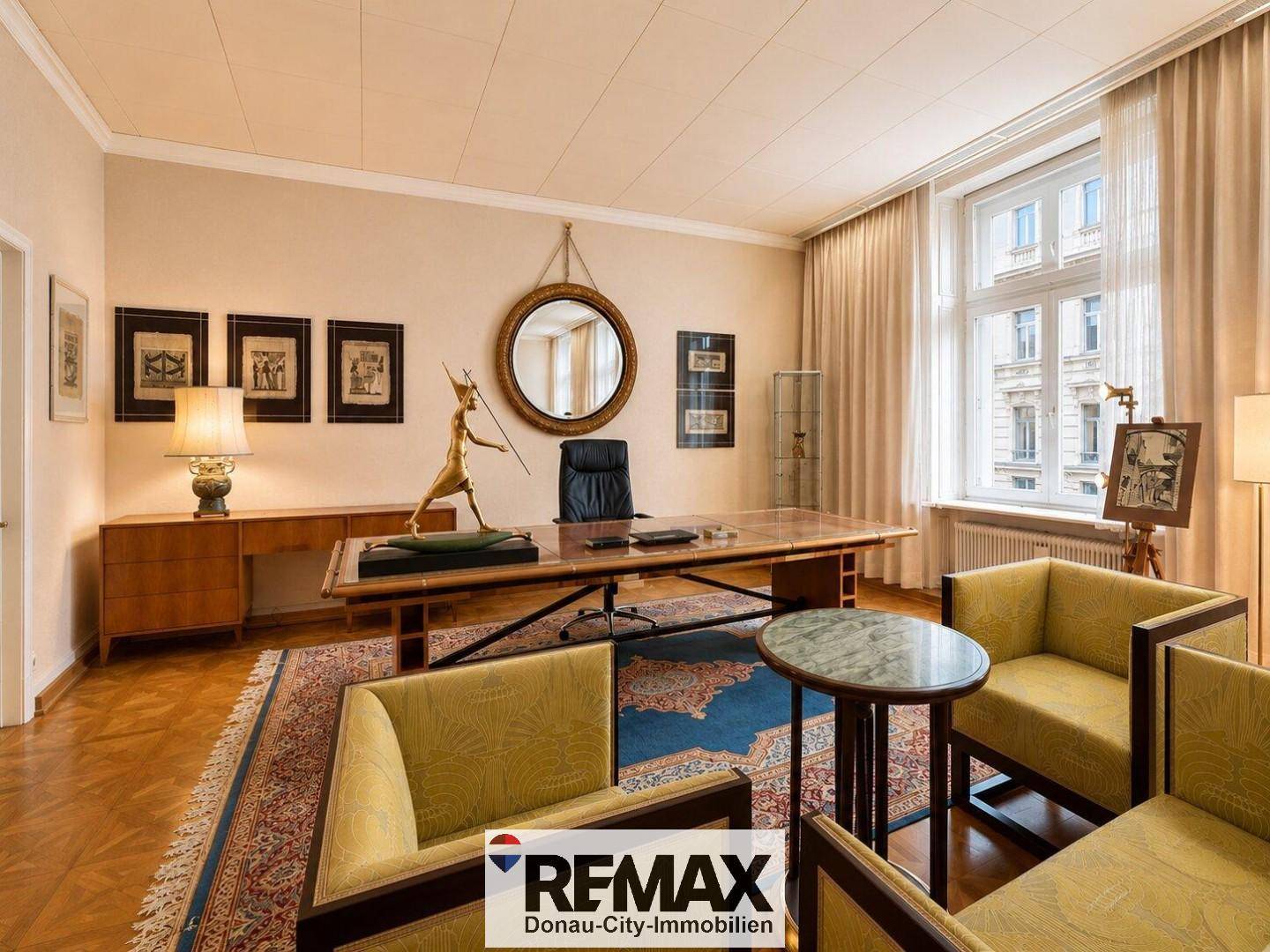 Elegantes Arbeitszimmer mit großem Schreibtisch, bequemen Sesseln und klassischem Parkettboden.