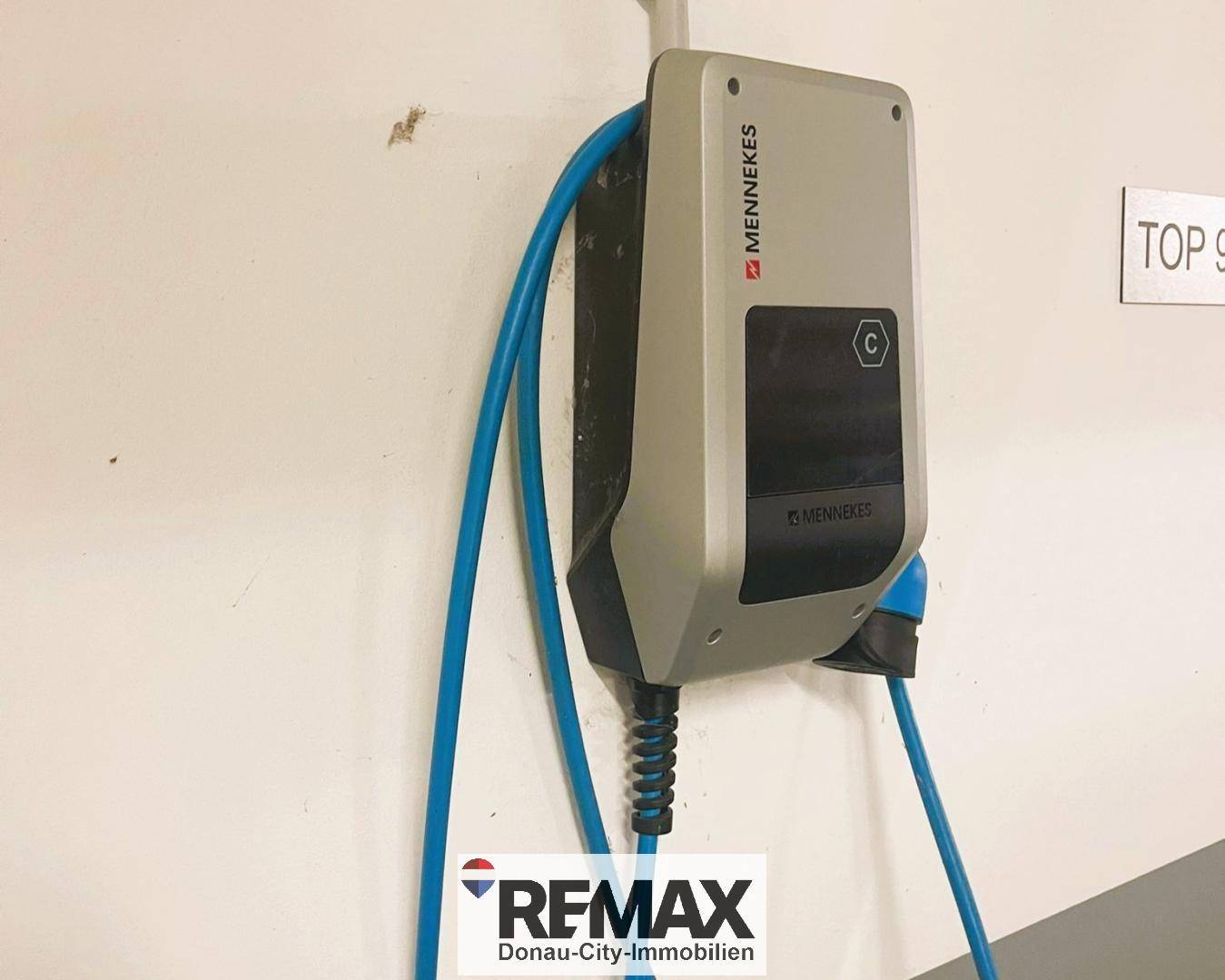 Nahaufnahme einer modernen Mennekes Ladestation für Elektrofahrzeuge in der Tiefgarage.