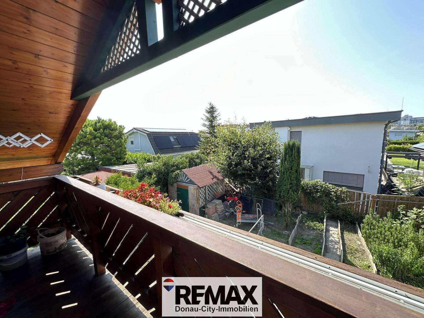 Blick vom Balkon auf den eigenen Garten und die benachbarten Häuser.