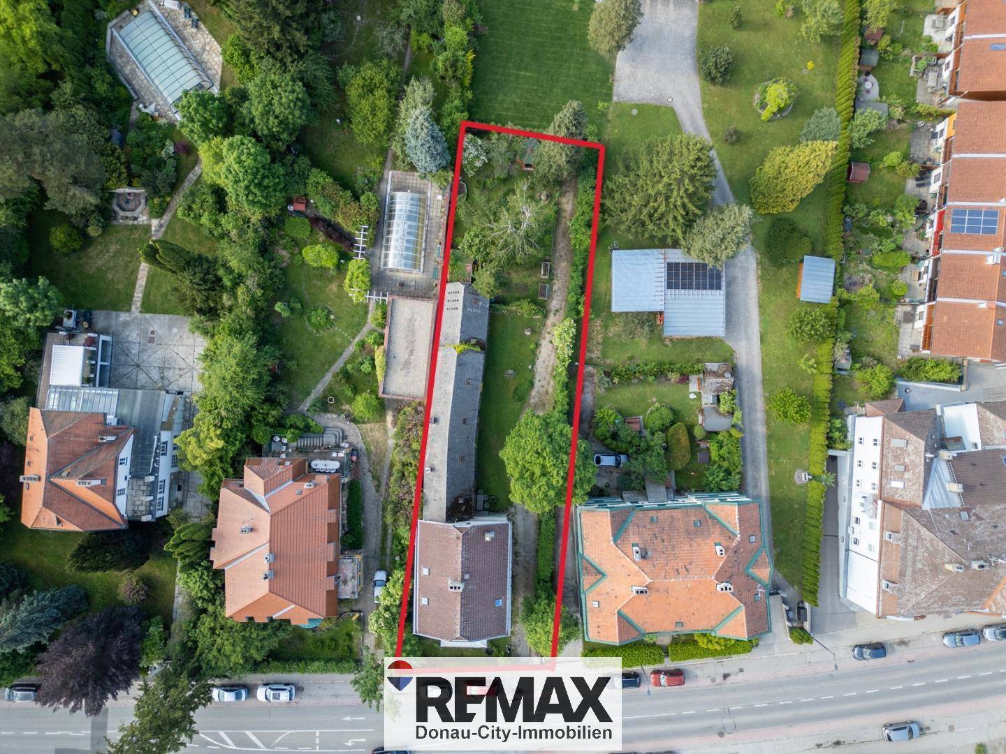 Luftbild des Grundstücks mit roter Umrandung, das das Hauptgebäude und Nebengebäude zeigt.