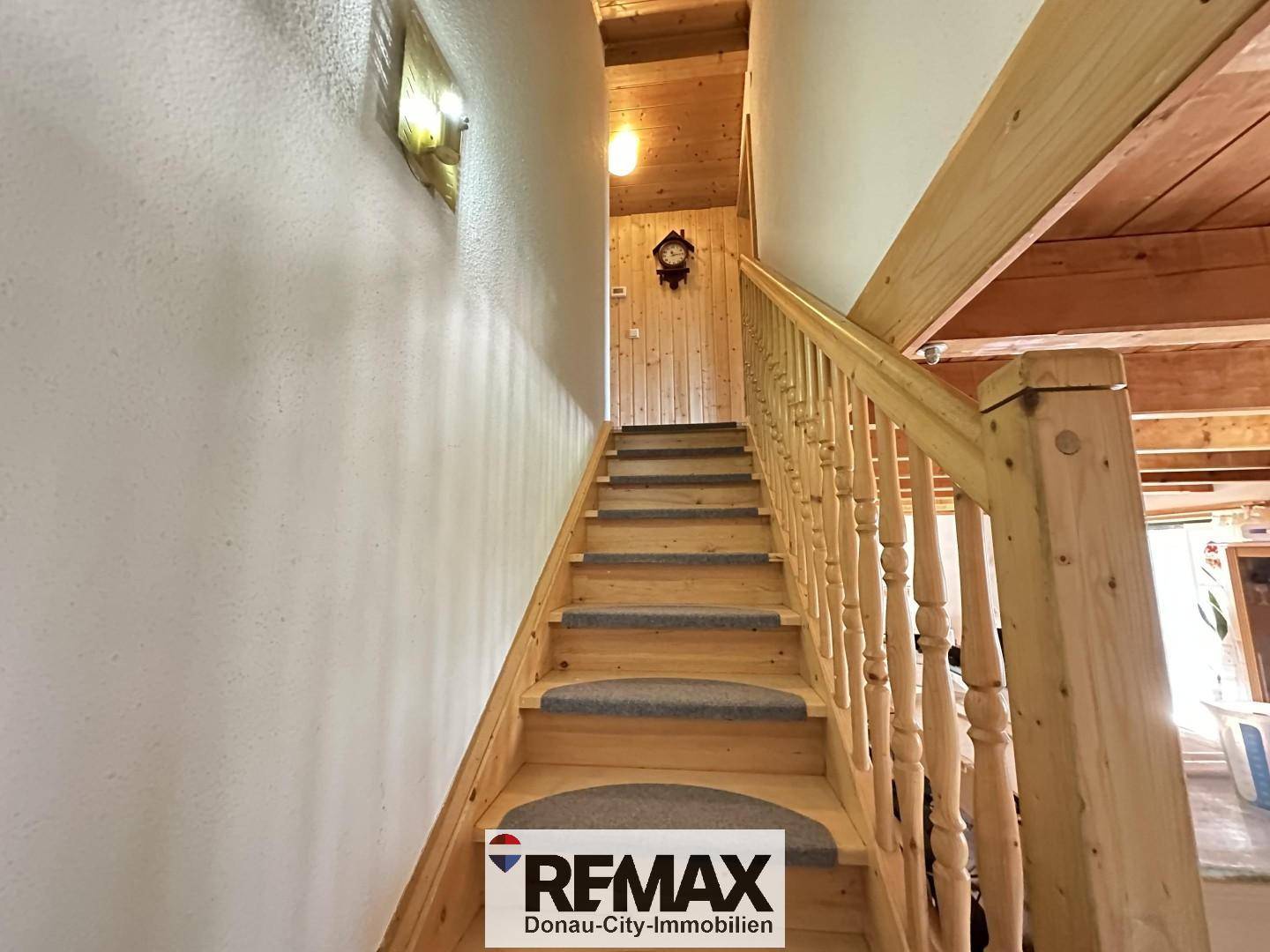 Holztreppe mit Teppichstufen führt in das obere Stockwerk des Hauses.