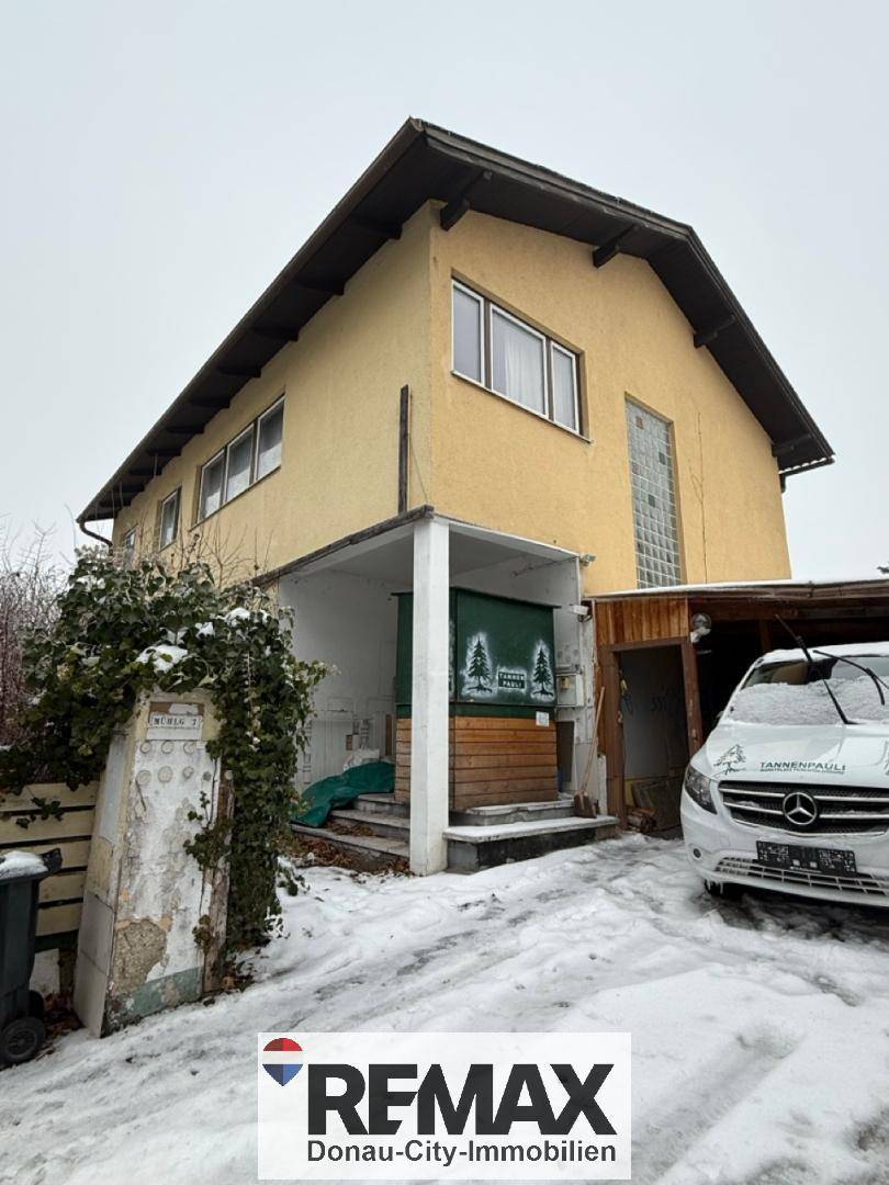 Gelbes Haus im Winter mit Schnee auf dem Boden und einem geparkten Auto davor, bereit zur Renovierung.