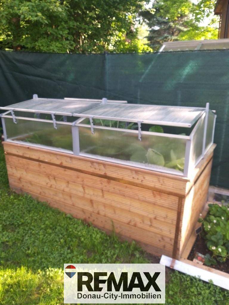 Hochbeet mit Frühbeetaufsatz im Garten, ideal für den Anbau von Gemüse.