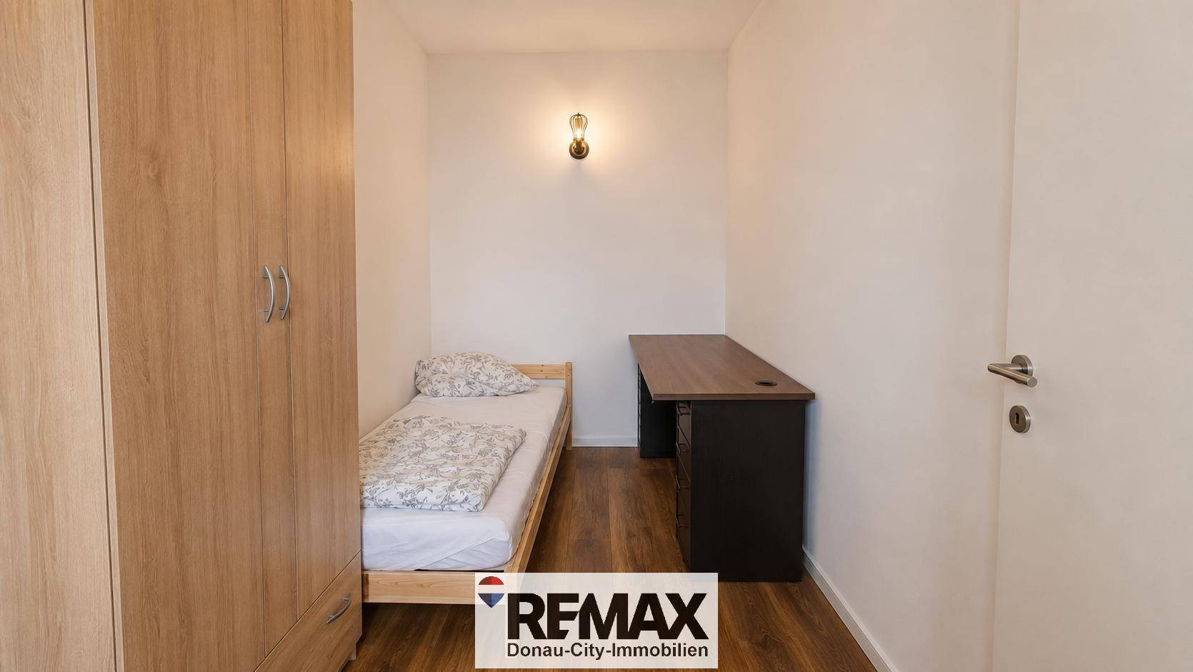 Kleines Schlafzimmer mit Einzelbett, Holzschrank und Schreibtisch, ideal als Gästezimmer oder Büro.