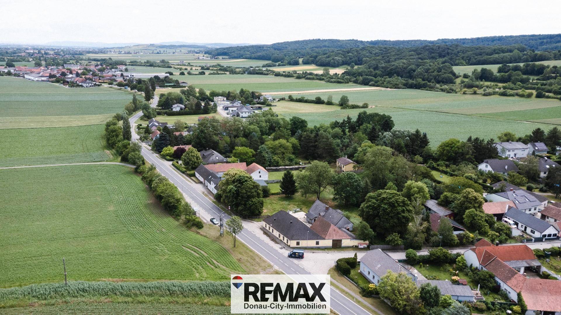 Panoramische Luftaufnahme des Anwesens eingebettet in weite Felder und grüne Landschaften.