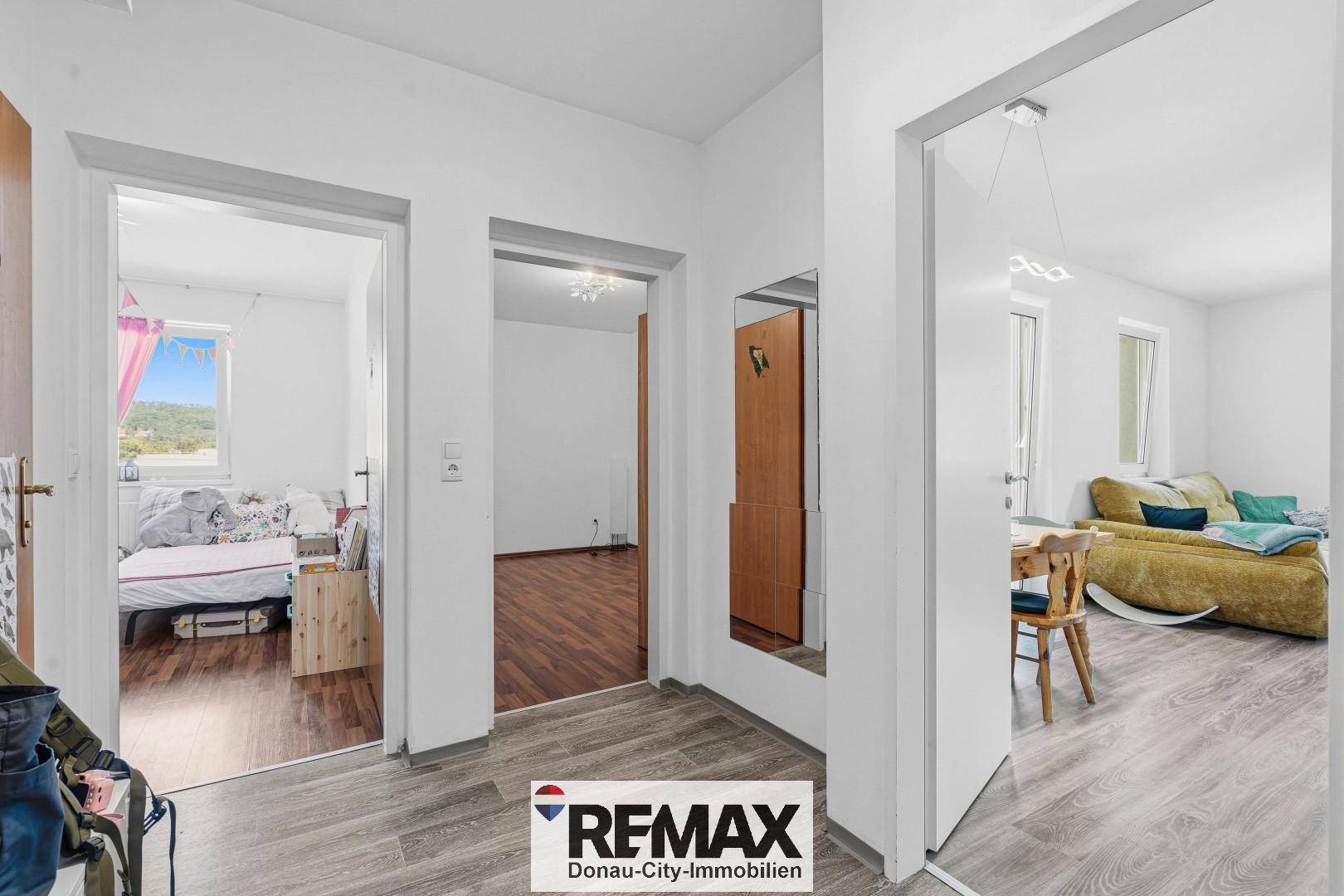 Heller Flur mit Laminatboden und Zugang zu verschiedenen Zimmern der Wohnung.